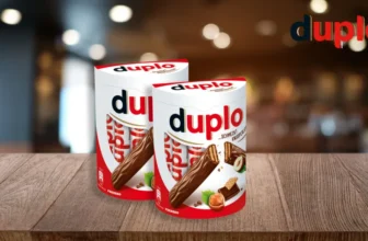 Packung Duplo Schokoriegel auf Holztisch mit rotem Hintergrund