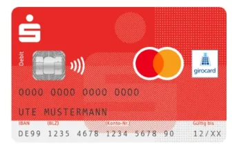 Glückliche Frau mit Sparkassen-Mastercard vor Laptop